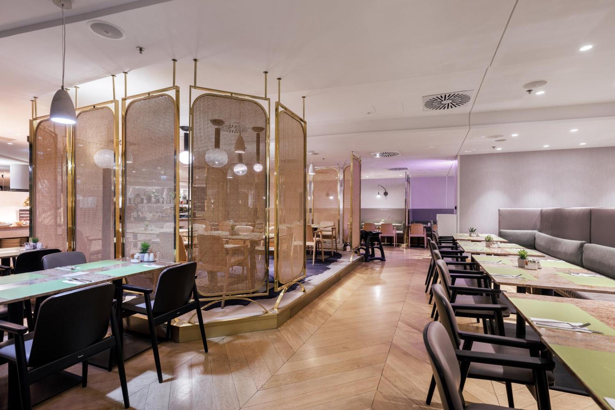 منتجع راديسون بلو سوينوجسي سفينويتشي المظهر الخارجي الصورة The photo depicts a modern restaurant interior. It features a layout with several tables and chairs arranged in an organized manner. There is a decorative partition made of delicate mesh or fabric, providing some privacy between different dining area