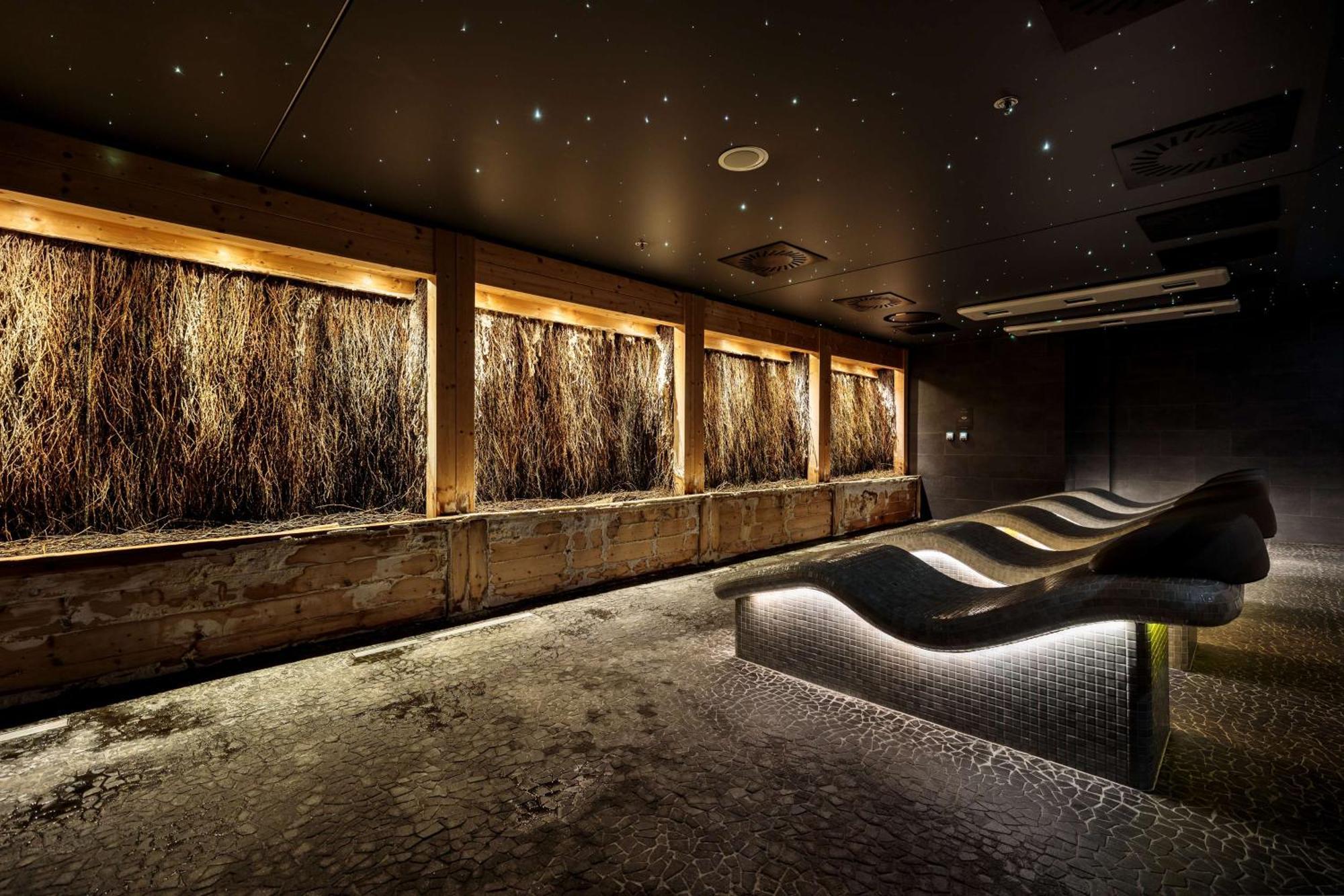 منتجع راديسون بلو سوينوجسي سفينويتشي المظهر الخارجي الصورة The photo depicts a modern, serene spa or relaxation space. It features several wooden-framed windows that showcase natural elements, possibly dried grass or plants, creating a calming atmosphere. The walls are dark, and the ceiling may have lights r